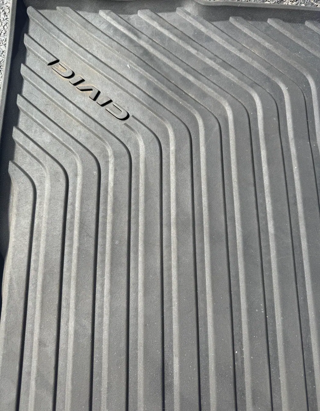 Honda Civic rubber floor mat being cleaned during interior detailing